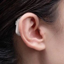 Mujer utilizando un audífono de diseño ergonómico